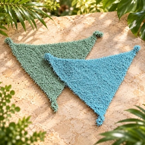 May include: Two triangular scrubbers with a textured, loopy surface. One scrubber is sage green, and the other is a bright turquoise blue. Both items feature small loops at the corners, showcasing a dense, scrubby knit construction for cleaning.
