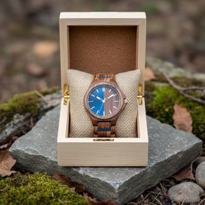 Peut inclure: Une tasse en céramique blanche avec une anse noire et le texte "But First, Coffee" en gras noir. La tasse est posée sur un fond neutre, soulignant son design simple.