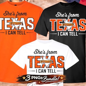May include: Three t-shirts in orange, black, and white, each featuring the text "She's from TEXAS - I CAN TELL." The word "TEXAS" is in large, bold letters with an outline of the state and the UTRGV logo.