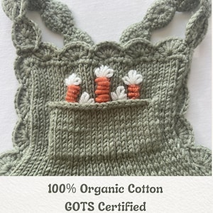 Puede incluir: Un pelele de bebé tejido de color verde salvia con bordes y tirantes festoneados. El pelele presenta un bolsillo bordado con diseños de zanahorias naranjas y blancas. El texto en la parte inferior dice "100% Organic Cotton, GOTS Certified, Suitable for sensitive skin, Soft and breathable."