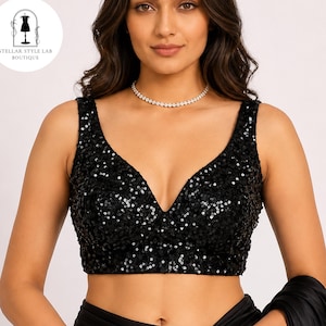 May include: A sleeveless black crop top covered in small, reflective sequins. The garment features a deep V-neckline and a fitted silhouette. A circular logo in the upper left corner displays the text Stellar Style Lab Boutique.