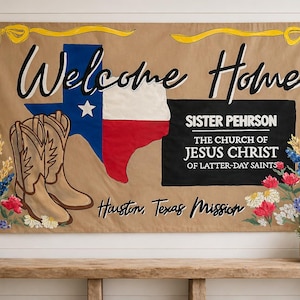 May include: A tan fabric banner featuring the text Welcome Home, a Texas state flag graphic, a pair of tan cowboy boots, and floral accents. The text reads Sister Pehrson, The Church of Jesus Christ of Latter-day Saints, and Houston, Texas Mission.
