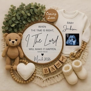 Puede incluir: Anuncio de bebé con un body blanco, imagen de ultrasonido y bloques de madera que deletrean "BABY". Un letrero redondo dice "When the time is right, I The Lord will make it happen. March 2026". Un osito de peluche de ganchillo y patucos completan la escena.