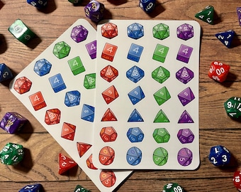 May include: Two sheets of stickers featuring colorful dice with different numbers. The stickers are on a wooden surface.