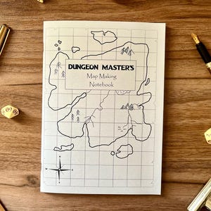 Può includere: Un taccuino "Dungeon Master's Map Making Notebook" con un disegno di mappa disegnato a mano, circondato da penne dorate, dadi e forbici su una superficie di legno. Il taccuino presenta una griglia e una rosa dei venti.