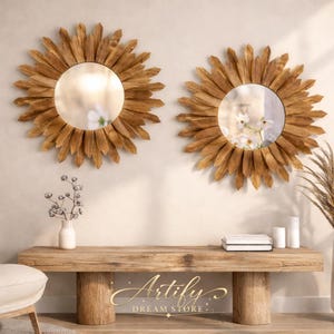 以下が含まれることがあります： 丸い反射面と木製フレームを備えた、2つの装飾的なサンバーストミラー。明るい色の壁に、木製のベンチの上に設置されています。ベンチには花瓶、本、キャンドルが置かれています。ミラーは温かみのある自然な木の色合いです。