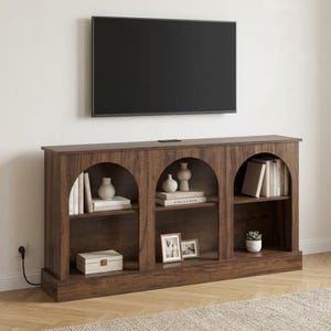 Puede incluir: Un mueble de entretenimiento de madera marrón oscuro con estantes arqueados. Los estantes exhiben libros, jarrones y objetos decorativos. Un televisor de pantalla plana negro está montado encima de la unidad. La unidad está contra una pared blanca.