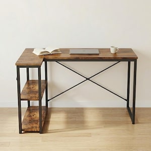 May include: An L-shaped desk with a brown wood-effect top and black metal frame. The desk features two shelves and has a laptop, open book, and mug on the surface. The desk is suitable for a home office or workspace.