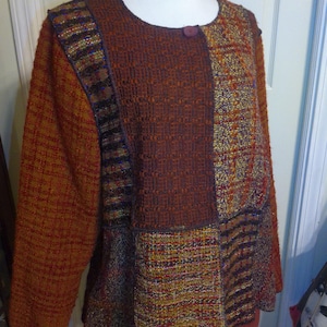 May include: A brown, multi-colored, woven jacket with a single button closure. The jacket has a patchwork design with different textures and patterns.