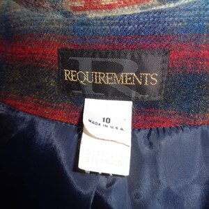 May include: A blue, red, and green plaid fabric jacket with a black satin lining. The jacket has a label that reads "Requirements" and a size tag that says "10 Made in U.S.A."