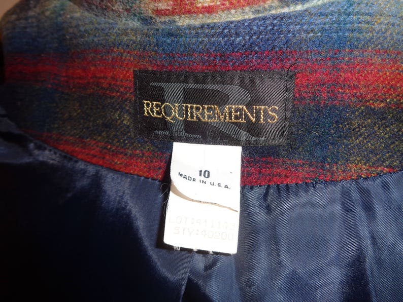 May include: A blue, red, and green plaid fabric jacket with a black satin lining. The jacket has a label that reads "Requirements" and a size tag that says "10 Made in U.S.A."
