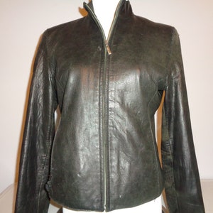 May include: A dark green leather jacket with a zipper closure. The jacket has a stand-up collar and long sleeves.