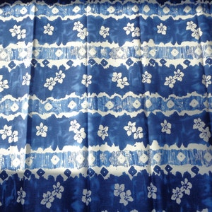 May include: Blue and white fabric with a repeating pattern of stylized flowers and wavy lines. The fabric has a slightly textured surface.