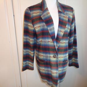 May include: A striped blazer with a southwestern pattern in shades of blue, red, and yellow. The blazer has a single button closure and two pockets.