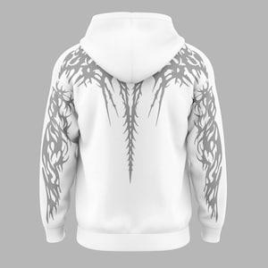 May include: A white hooded sweatshirt featuring a grey graphic print that extends from the shoulders down the sleeves and across the upper back. The design consists of sharp, elongated, and symmetrical lines resembling organic, thorn-like shapes.