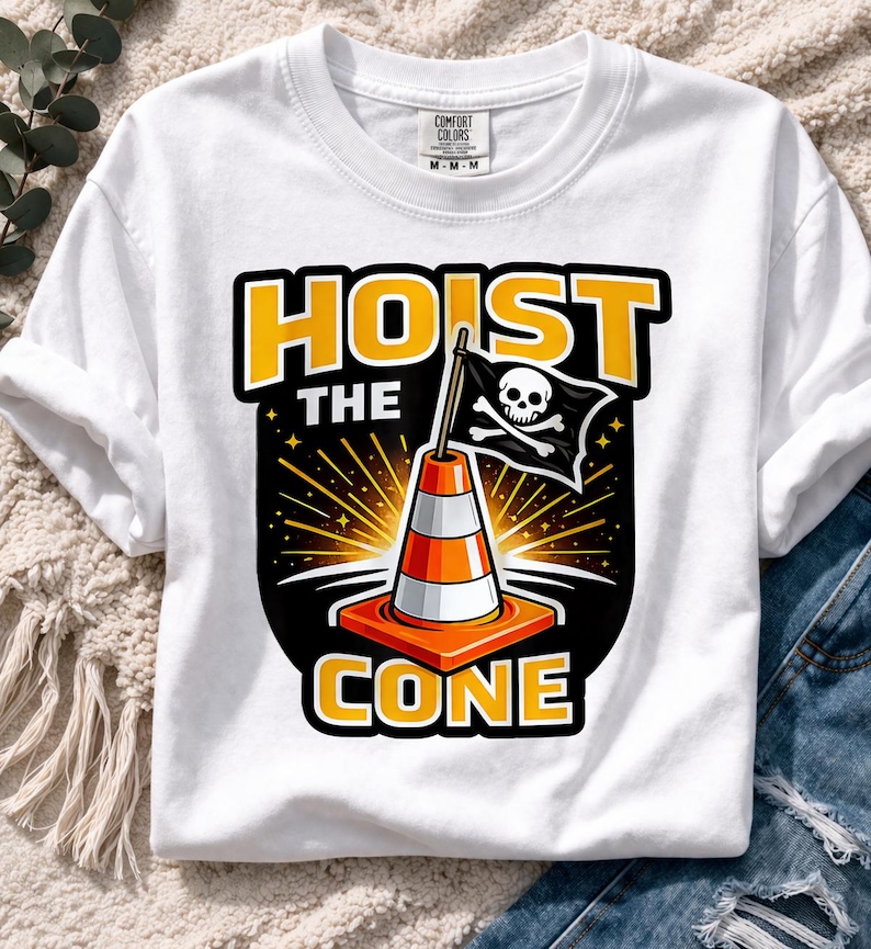May include: White t-shirt with a graphic featuring a traffic cone with a pirate flag and the words "HOIST THE CONE" in yellow and black. The shirt has a crew neck and short sleeves.