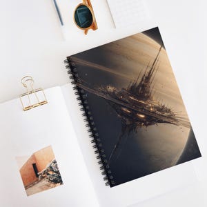 May include: Spiral-bound notebook featuring a detailed, futuristic cityscape design against a planetary backdrop. The cover art showcases a complex structure with illuminated elements, set against a gradient of dark and light tones. The notebook is open on a white surface.