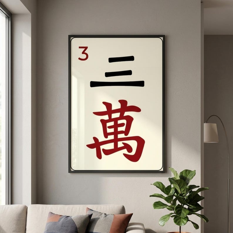 Puede incluir: Arte mural enmarcado con un dise&ntilde;o de ficha de Mahjong. La ficha muestra el n&uacute;mero "3" en rojo, junto con tres l&iacute;neas negras horizontales y el car&aacute;cter chino "萬" en rojo. La obra de arte est&aacute; sobre un fondo crema.