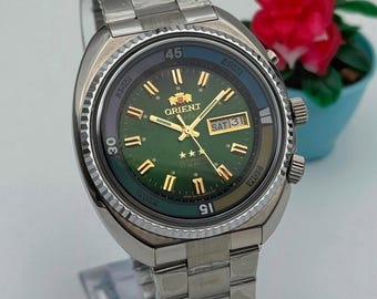 Reloj vintage Orient Tri Star automático con esfera verde con efecto sol, acero inoxidable, día y fecha