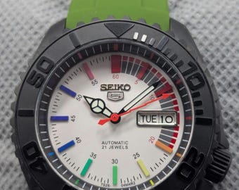 Reloj deportivo vintage Seiko 5 automático con esfera blanca y bisel negro, día y fecha para hombre