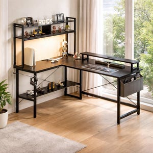 May include: Black L-shaped computer desk with a hutch and shelves. The desk has a black metal frame and a dark wood-grain surface. The hutch features a shelf with the word "ROCK" and decorative items. A keyboard, mouse, and monitor are on the desk.