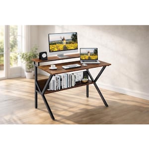 May include: A brown and black computer desk with a monitor, laptop, and books. The desk has a two-tiered design with a top surface for the computer and a lower shelf for storage. The desk is supported by black metal legs.