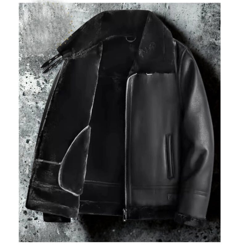 May include: Black leather jacket with a shearling lining and collar. The jacket has a zipper closure, two front pockets, and a classic aviator style. The interior lining is visible, providing warmth and comfort. The jacket is designed for cold weather.