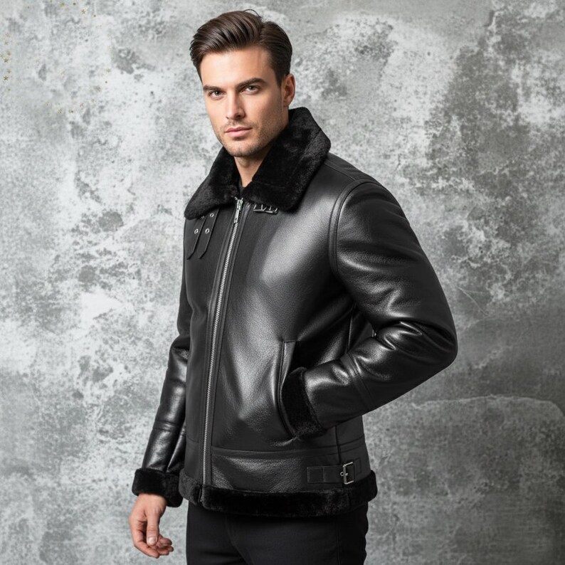 May include: A black leather jacket with a shearling collar and cuffs. The jacket features a front zipper closure, two side pockets, and a buckled belt detail at the waist. The jacket is a classic style, suitable for cold weather.
