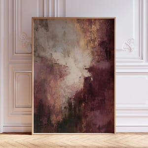May include: Abstract art print in a wooden frame. The artwork features a blend of colours, including burgundy, cream, and gold, with visible brushstrokes. The painting has a textured appearance, creating a sense of depth and movement. The overall theme is modern and artistic.