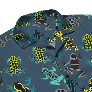 Peut inclure: Une chemise boutonnée bleue avec un motif de grenouilles colorées. Les grenouilles sont dans différentes poses et ont des couleurs et des motifs différents.