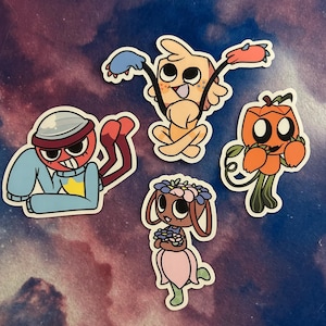 Könnte beinhalten: Eine Sammlung von vier Aufklebern mit Cartoon-Charakteren. Eine Figur ist eine rotgesichtige Figur in einem blauen Pullover und einem silbernen Hut. Eine weitere ist eine hellorangefarbene Kreatur mit blauen und rosa Anhängen. Eine Kürbiskopffigur und eine kaninchenartige Figur.
