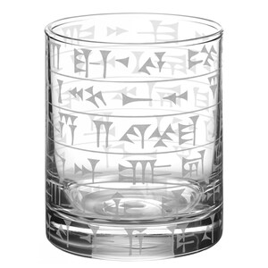 May include: A clear, cylindrical drinking glass with etched ancient script. The glass features horizontal bands of stylized characters, creating a unique and historical aesthetic. Ideal for serving beverages, this glass adds a touch of sophistication to any table setting.