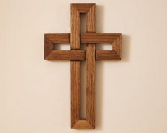 May include: A wall-mounted cross crafted from medium-brown wood with a visible grain. The design features an interlocking, geometric structure where the vertical and horizontal bars appear to weave through one another, creating an open frame.