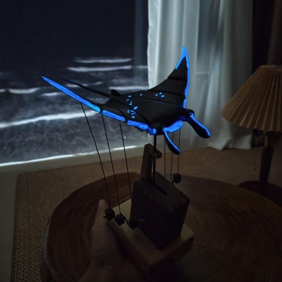 A hand-carved wooden automaton manta ray that actually moves AND glows in the dark with your zodiac constellation — no two are alike and the craftsmanship is wild.
