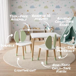 May include: A white children's table and two chairs set with light green accents. The chairs have a unique leaf-shaped backrest. The table and chair legs are natural wood with green tips. The set is lightweight, durable, and has rounded child-safe edges.