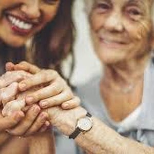May include: A silver wristwatch with a black band is visible on a person's wrist. The watch has a round face and a simple design. The image shows two people holding hands, with the watch in focus.