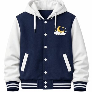 Op de afbeelding: Marineblauwe en witte varsity-jas met capuchon. De jas heeft witte mouwen, een marineblauwe body en een witte capuchon. Het heeft een drukknoopsluiting en een ontwerp van een gele maan, wolken en sterren op de borst.
