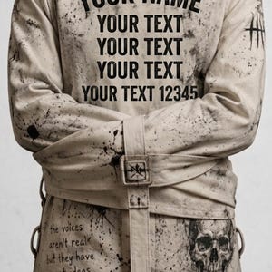 May include: A beige long-sleeve straightjacket featuring black paint splatters, a central buckle strap, and printed text reading YOUR NAME, YOUR TEXT, and the voices aren't real but they have great ideas, plus a skull graphic on the lower front.