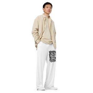 Puede incluir: Pantalones blancos de pernera ancha con un gráfico de león negro. La persona de la imagen lleva una camisa abotonada color beige sobre una camiseta a juego. Los pantalones son de material suave.