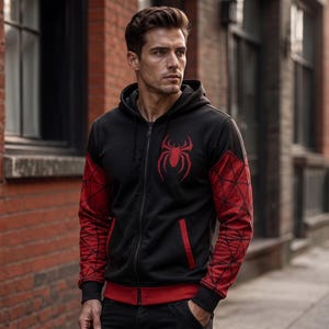May include: Black zip-up hoodie with red accents and a red spider emblem on the chest. The sleeves feature a red web design. The hoodie has a red trim at the bottom and around the pockets.