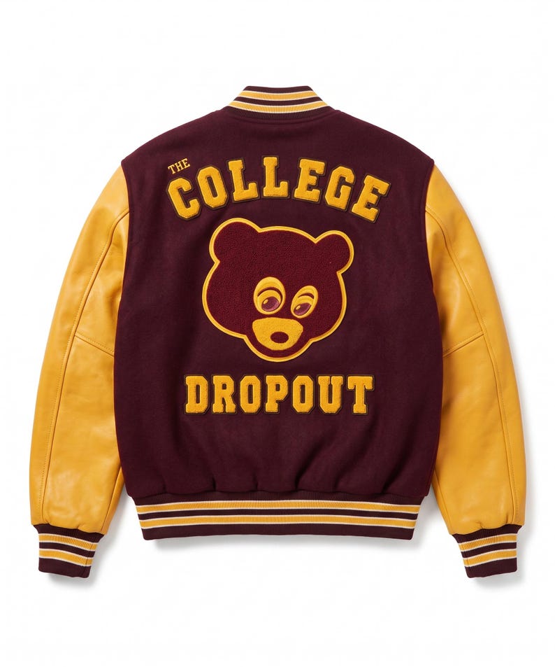 Puede incluir: Chaqueta universitaria granate y dorada con la inscripci&oacute;n "THE COLLEGE DROPOUT" y un gr&aacute;fico de oso. La chaqueta tiene mangas de cuero dorado y pu&ntilde;os y cuello a rayas.