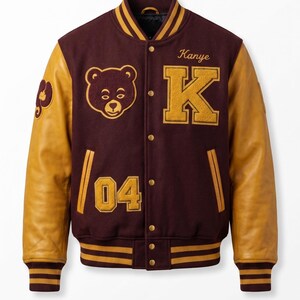 Puede incluir: Chaqueta universitaria granate y dorada con mangas de cuero. La chaqueta presenta un parche de cabeza de oso, la letra "K", el n&uacute;mero "04" y el nombre "Kanye". El cuello, los pu&ntilde;os y la cintura tienen rayas doradas.