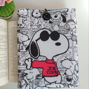 Capa protetora acolchoada para livros Snoopy Peanuts Joe Cool, 21x27cm, ideal para tablets e quadrinhos, um ótimo presente para leitores. Feita em tecido.
