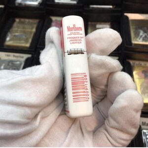 May include: A white and red Marlboro lighter with the text "Marlboro Selected Fine Tobaccos" and "Produce by Jingming Lighter". The lighter has a barcode and the number "20091208" printed on it.
