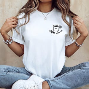 Könnte beinhalten: Ein Set aus drei Keramikbechern mit gesprenkelter, matter Oberfläche. Die Becher sind in den Farbtönen Creme, Hellgrau und Dunkelgrau gehalten. Jeder Becher hat ein schlichtes, minimalistisches Design und einen abgerundeten Henkel.