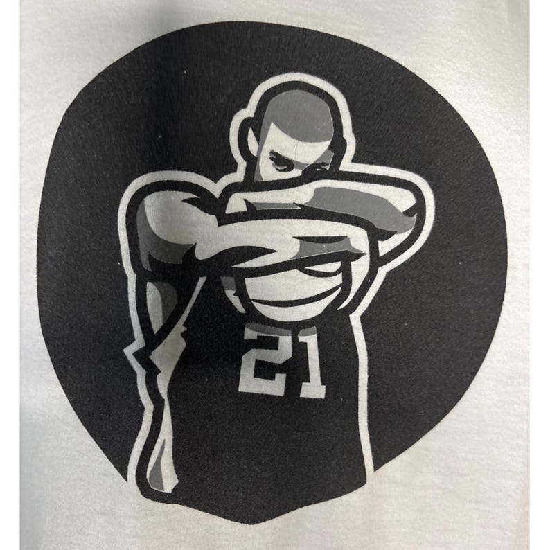 May include: A black and white graphic of a basketball player in a stylized pose, set against a black circular background. The player is wearing a jersey with the number 21. The image is a simple, bold design.