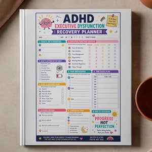 May include: A white ADHD Executive Dysfunction Recovery Planner with colorful sections for daily planning. The planner includes sections for priorities, executive function check-in, task breakdown, and evening review. The cover features the text "ADHD Executive Dysfunction Recovery Planner".
