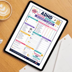 May include: A digital tablet displaying an ADHD Executive Dysfunction Recovery Planner. The planner features sections for daily priorities, executive function check-ins, task breakdowns, and a time block plan. The planner's design includes colorful graphics and motivational text.