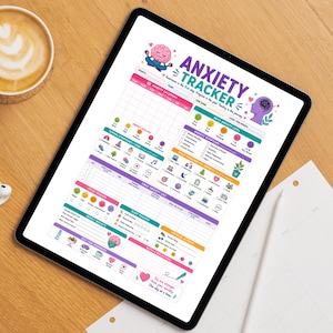 Può includere: Un tablet digitale mostra un tracker dell'ansia colorato con sezioni per l'umore, il sonno e i registri giornalieri. Il tracker include il testo "Anxiety Tracker" e varie icone. Il tablet è appoggiato su una superficie di legno, con una tazza di caffè visibile sullo sfondo.
