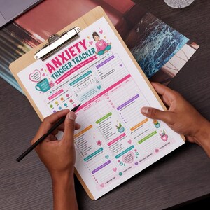 Op de afbeelding: Een houten clipboard met een "Anxiety Trigger Tracker"-blad. Het blad heeft kleurrijke secties voor het volgen van triggers, intensiteit en copingstrategieën. Een persoon houdt het clipboard vast en schrijft met een zwarte pen.